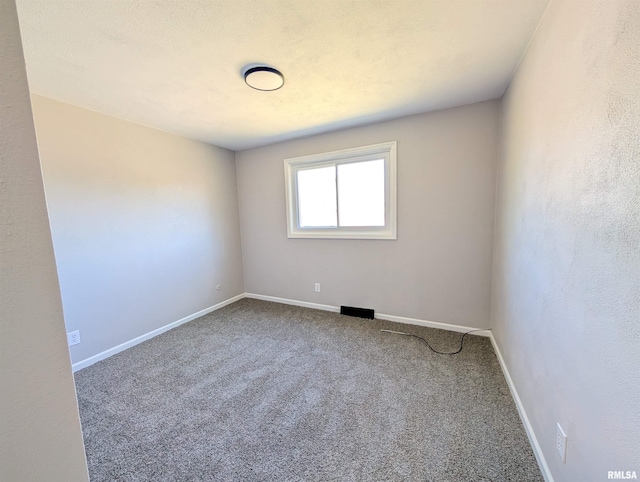 empty room featuring carpet floors and baseboards