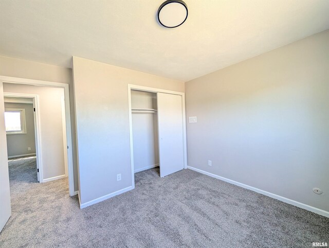 unfurnished bedroom featuring carpet flooring, a closet, and baseboards