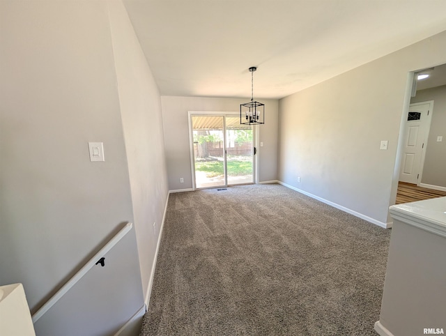 unfurnished dining area with a chandelier, carpet, and baseboards
