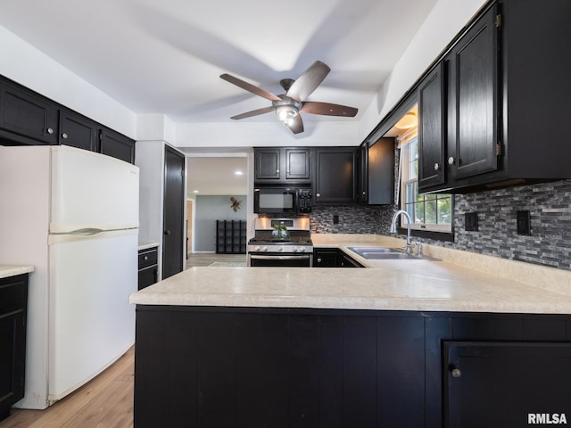 106 N 5th St, Dunlap, IL 61525 - kitchen featuring freestanding refrigerator, black microwave, stainless steel gas range, dark cabinetry, and a ceiling fan