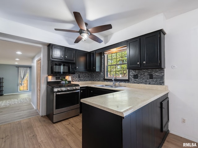 106 N 5th St, Dunlap, IL 61525 - kitchen featuring stainless steel gas range, black microwave, a peninsula, light countertops, and decorative backsplash