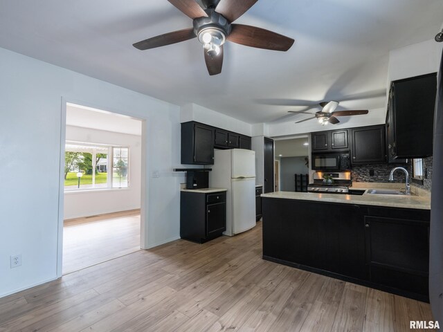 106 N 5th St, Dunlap, IL 61525 - kitchen with black microwave, dark cabinets, freestanding refrigerator, and ceiling fan