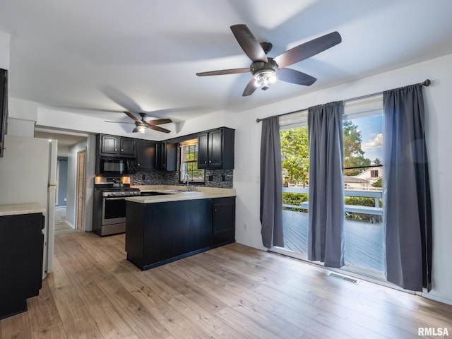 106 N 5th St, Dunlap, IL 61525 - kitchen with stainless steel range with gas stovetop, black microwave, freestanding refrigerator, a peninsula, and a ceiling fan