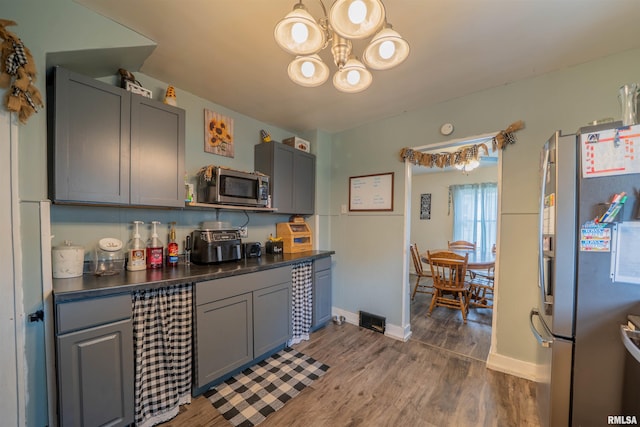 kitchen with stainless steel appliances, dark countertops, and gray cabinetry