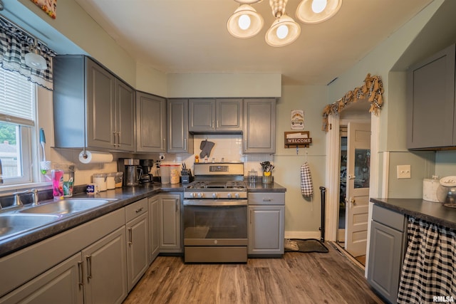 kitchen featuring stainless steel range with gas stovetop, gray cabinets, and light wood-style floors