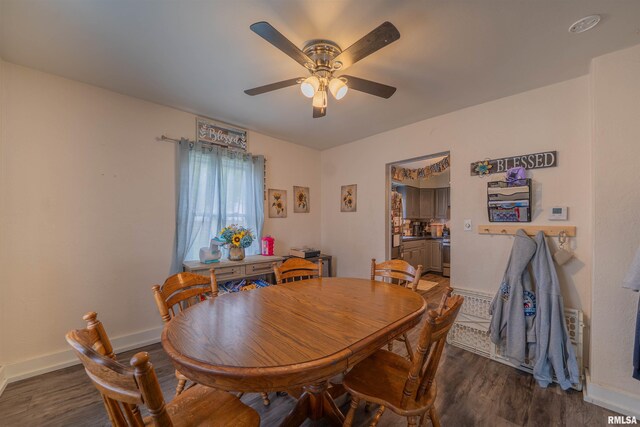 dining room with wood finished floors, a ceiling fan, and baseboards