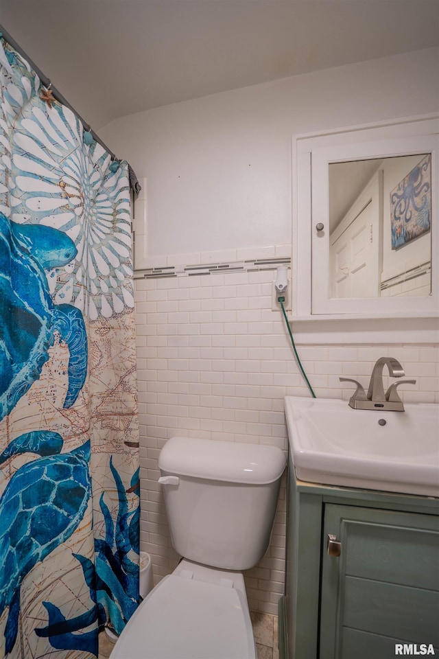 full bath with vanity, tile walls, toilet, wainscoting, and curtained shower