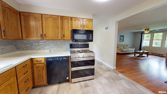 kitchen with black appliances, brown cabinets, tasteful backsplash, and light countertops