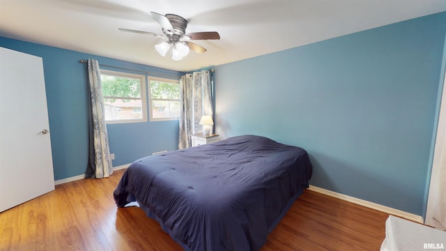 bedroom featuring wood finished floors, baseboards, and ceiling fan