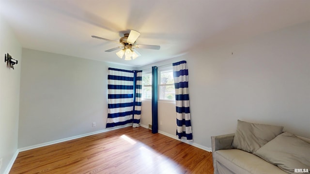 sitting room with wood finished floors, ceiling fan, and baseboards