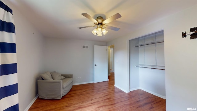 unfurnished room with wood finished floors, ceiling fan, and baseboards