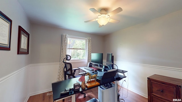 office space featuring a ceiling fan, baseboards, and wood finished floors