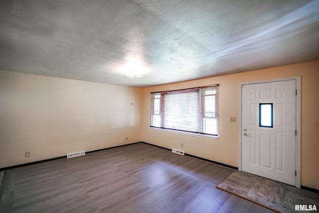 foyer entrance with wood finished floors and baseboards