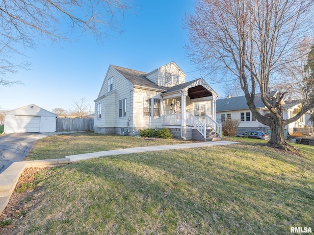 view of front of home with a detached garage, a porch, and asphalt driveway