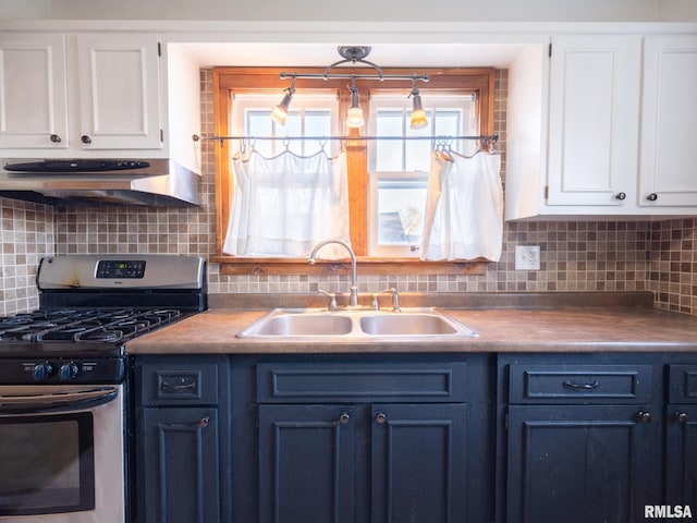 kitchen featuring stainless steel range with gas stovetop, a sink, blue cabinets, under cabinet range hood, and white cabinetry