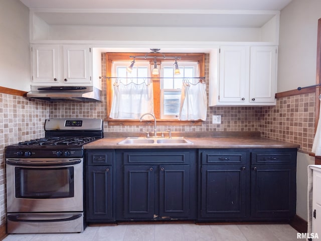 kitchen featuring stainless steel gas range oven, under cabinet range hood, a sink, and white cabinetry