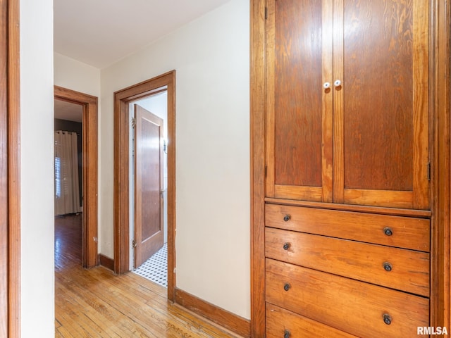 hallway featuring light wood-type flooring and baseboards