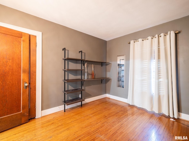 unfurnished room featuring light wood-style flooring and baseboards