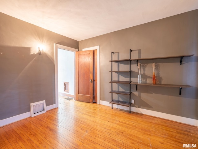 spare room with hardwood / wood-style floors and baseboards