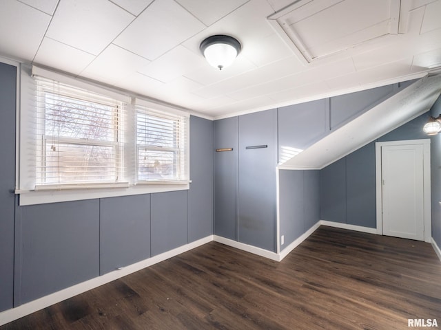 bonus room with dark wood-style floors and baseboards