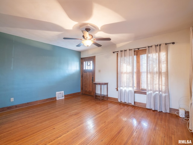 unfurnished room with a ceiling fan, hardwood / wood-style floors, and baseboards