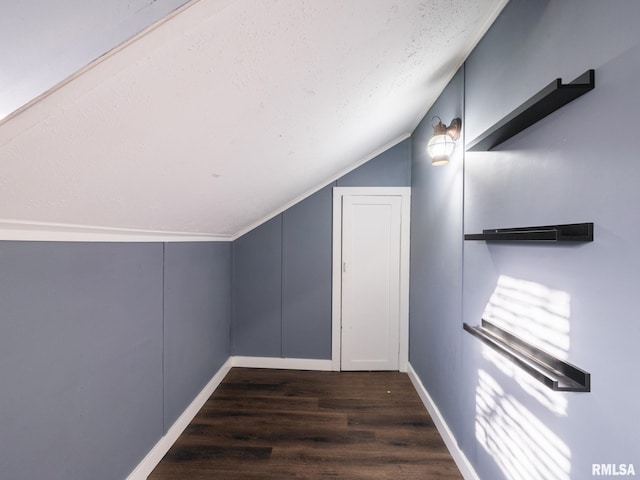 bonus room featuring vaulted ceiling, wood finished floors, baseboards, and a textured ceiling