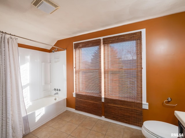bathroom with tile patterned floors, shower / tub combo with curtain, lofted ceiling, toilet, and baseboards