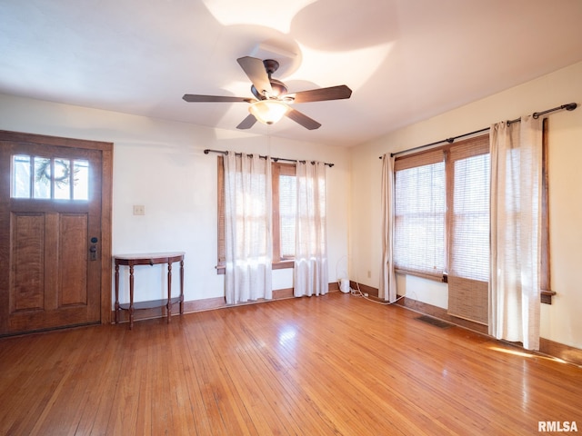 foyer entrance featuring light wood-style floors, a ceiling fan, baseboards, and healthy amount of natural light