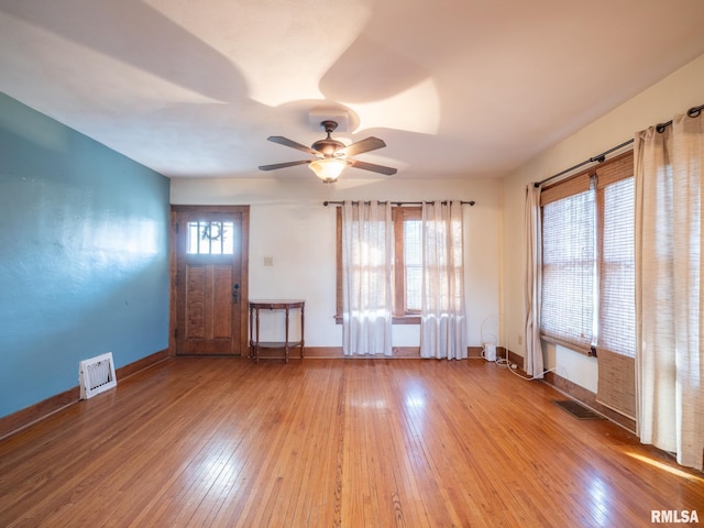 spare room featuring hardwood / wood-style flooring, a ceiling fan, and baseboards