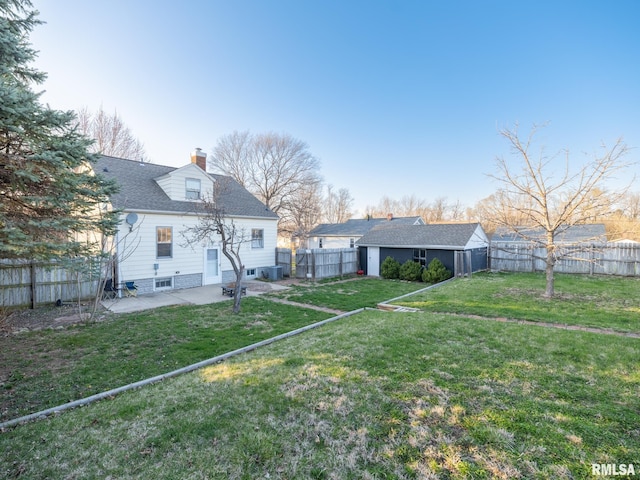 rear view of property with a patio, a chimney, an outdoor structure, and central AC unit