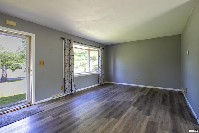 empty room with dark wood finished floors and baseboards