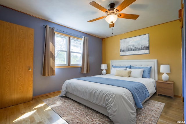bedroom featuring wood finished floors, baseboards, and ceiling fan
