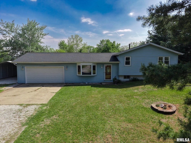 tri-level home featuring driveway, a garage, a front lawn, and a fire pit