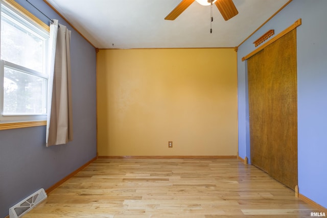 spare room with ceiling fan, light wood-style flooring, and baseboards