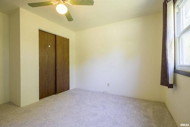 unfurnished bedroom with carpet floors, a closet, and ceiling fan