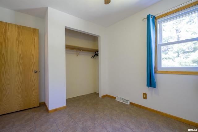 unfurnished bedroom with a closet and baseboards