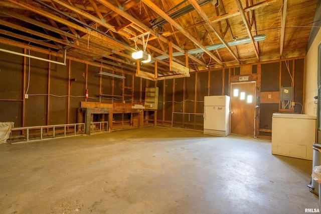 garage with freestanding refrigerator and electric panel