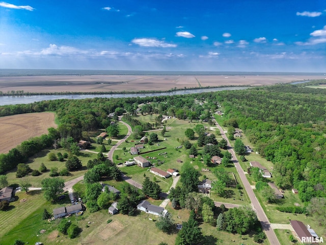 view of property location with a large body of water and a heavily wooded area