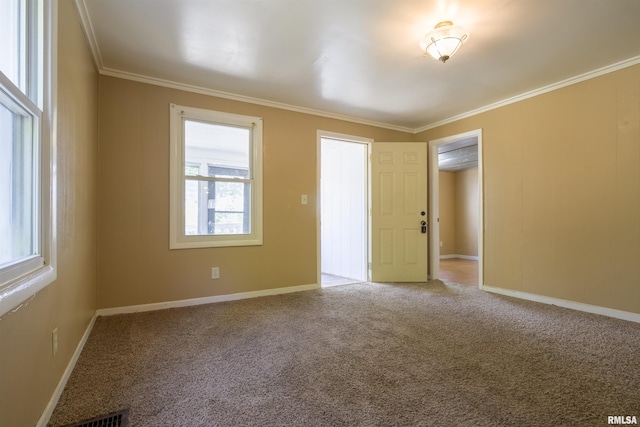carpeted empty room with ornamental molding and baseboards