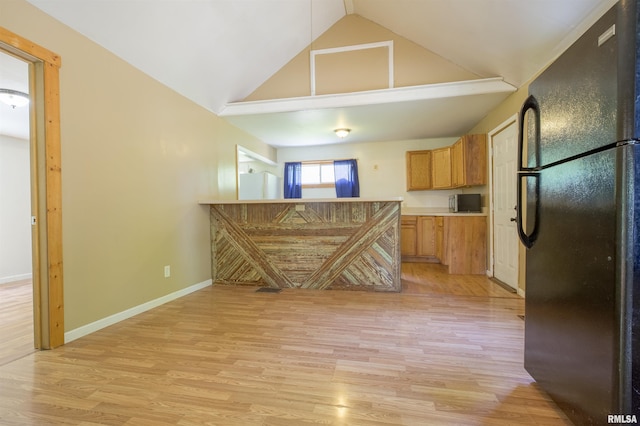 kitchen featuring freestanding refrigerator, light wood finished floors, high vaulted ceiling, brown cabinets, and baseboards