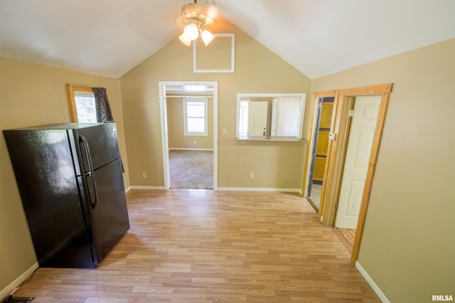 kitchen featuring freestanding refrigerator, ceiling fan, light wood-style flooring, vaulted ceiling, and baseboards