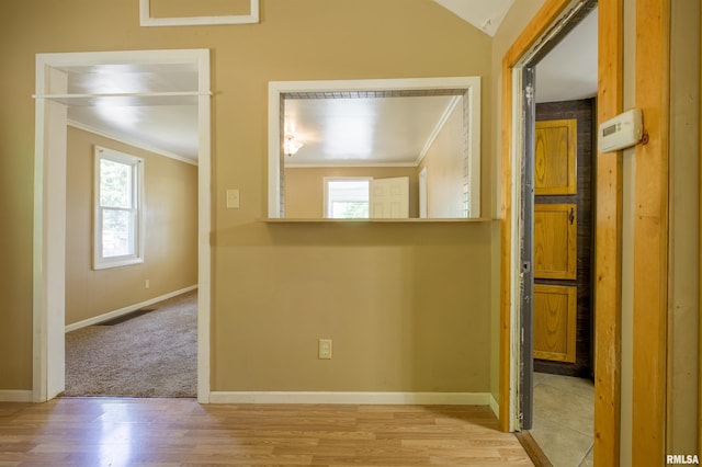empty room featuring ornamental molding, plenty of natural light, wood finished floors, and baseboards