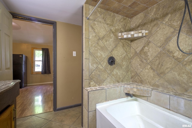 full bath with a tub to relax in, a shower, and baseboards