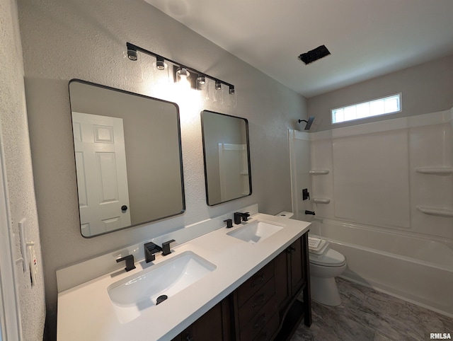 full bath with toilet, tub / shower combination, double vanity, and a textured wall