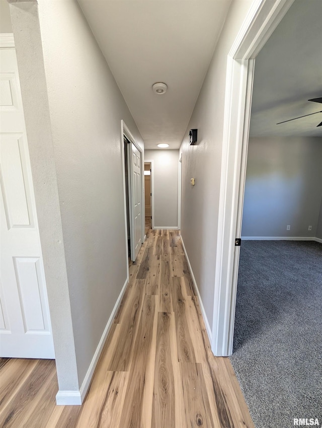 hall featuring light wood-style floors and baseboards