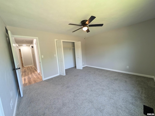 unfurnished bedroom featuring carpet floors, a closet, baseboards, and ceiling fan
