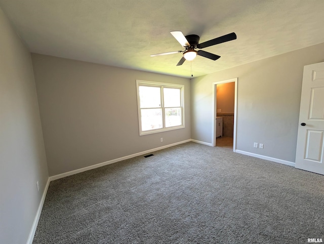 unfurnished bedroom featuring baseboards, carpet flooring, connected bathroom, and a ceiling fan