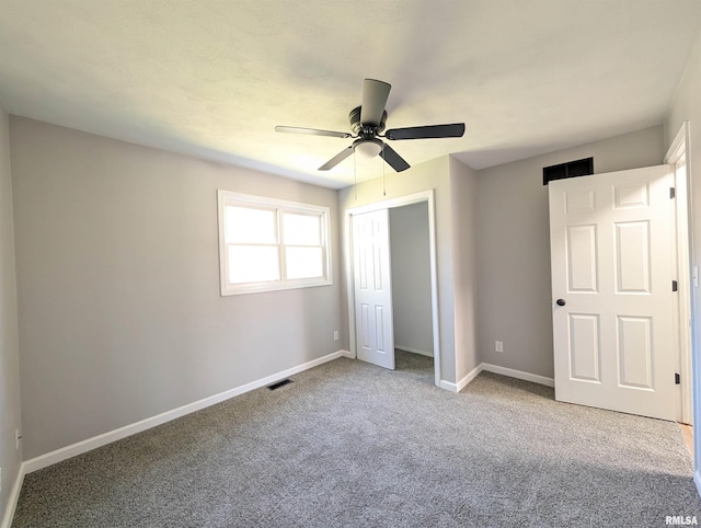 unfurnished bedroom with baseboards, a closet, carpet floors, and a ceiling fan
