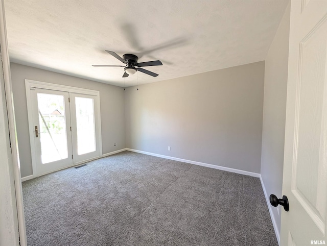 carpeted empty room featuring a ceiling fan and baseboards