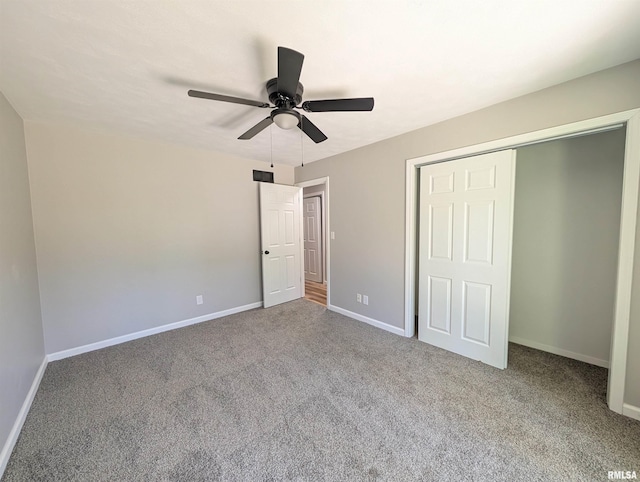 unfurnished bedroom with carpet flooring, baseboards, a closet, and a ceiling fan